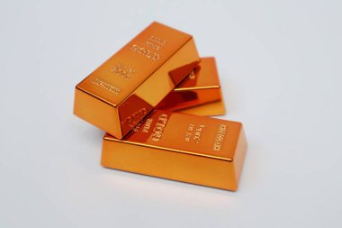 Beyaz arka planda parlayan altın külçeleri