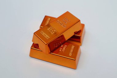 Beyaz arka planda parlayan altın külçeleri