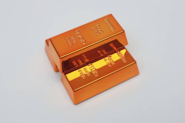 Beyaz arka planda parlayan altın külçeleri