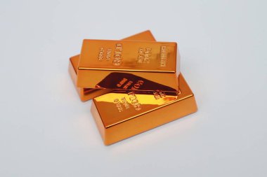 Beyaz arka planda parlayan altın külçeleri