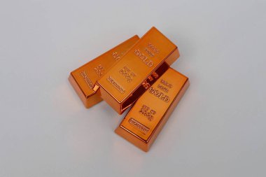 Beyaz arka planda parlayan altın külçeleri