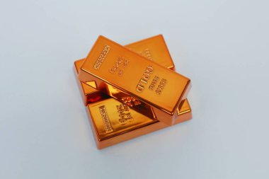 Beyaz arka planda parlayan altın külçeleri