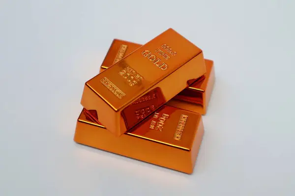 Beyaz arka planda parlayan altın külçeleri