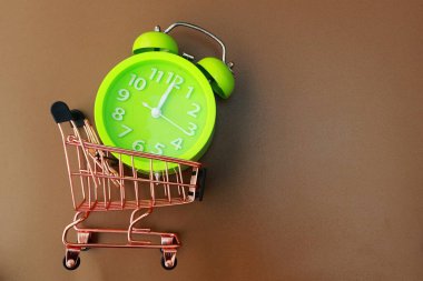 Kahverengi arkaplanda pembe trollü ve alarm saati