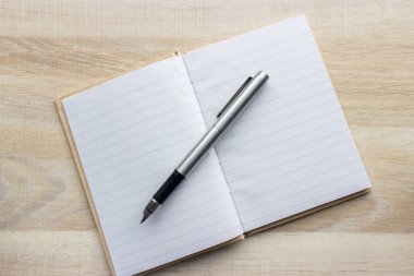 Masada duran defter ve kalem.