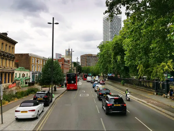 stock image Stratford: a street with cars and a bus surrounded by greenery