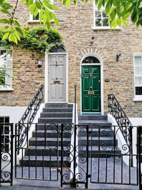 Hampstead: Gri giriş kapısı ve koyu yeşil giriş kapısı. Merdiven ve parmaklıklar. İngiliz tuğla ve yeşillik inşaatı.