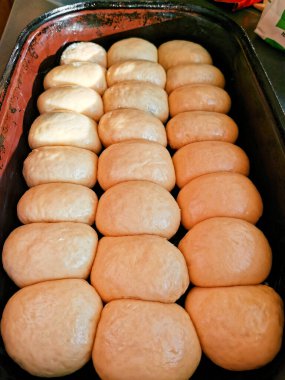 Pişirmeden önce fırında çörek, başka bir manzara. Fırınlanmaya hazır eski bir diş minesi tepsisinde yükseltilmiş çörekler. Ayrıntılı görünüm.