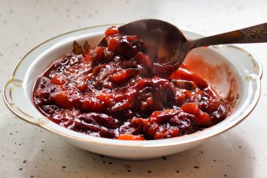 Geleneksel bir kase ev yapımı, sıcak ve buharlı erik reçeli.