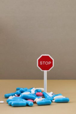 Uyuşturucu bağımlılığı; bu kadar çok ilaç almayı bırak; dur işaretli çok renkli haplar yığını