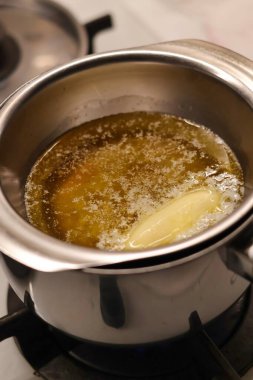 Ev yapımı yulaf ezmeli kurabiye hazırlama süreci. Tereyağı ve bal, metal bir kasede eridi.