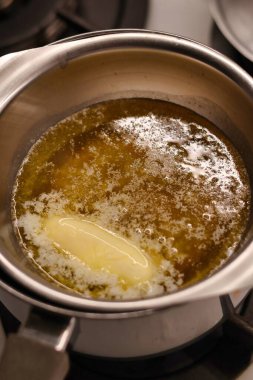 Ev yapımı yulaf ezmeli kurabiye hazırlama süreci. Tereyağı ve bal, metal bir kasede eridi.
