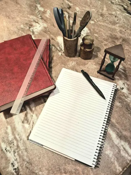 Kitaplar ve defter mermer masanın üzerinde.
