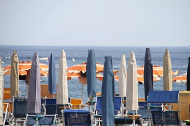 Sahilin önünde birkaç şemsiye var.