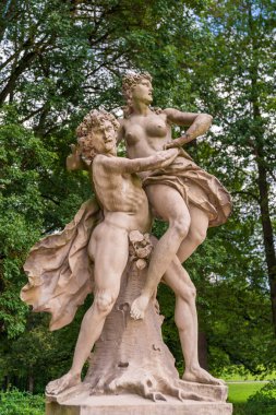 Bir kadının yanındaki adamın heykeli.