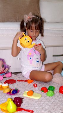 Oyuncak tabaklar ve sebzelerle oynayan kız. Yüksek kalite fotoğraf