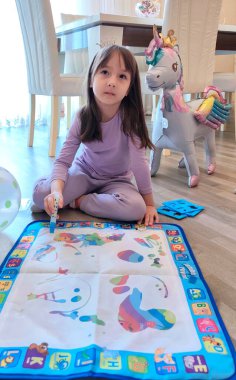 Küçük kız su kalemiyle özel çizim minderini çiziyor. Yüksek kalite fotoğraf