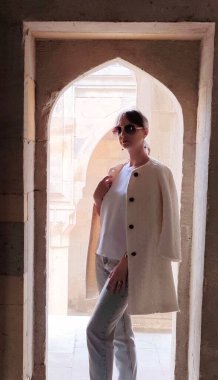 Genç kadın dışarıda beyaz önlüklü poz veriyor. Yüksek kalite fotoğraf