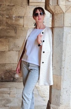 Genç kadın dışarıda beyaz önlüklü poz veriyor. Yüksek kalite fotoğraf