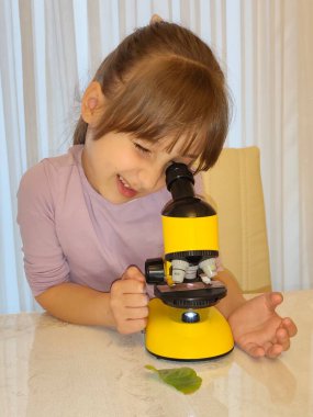 Kız ve mikroskop. Yüksek kalite fotoğraf