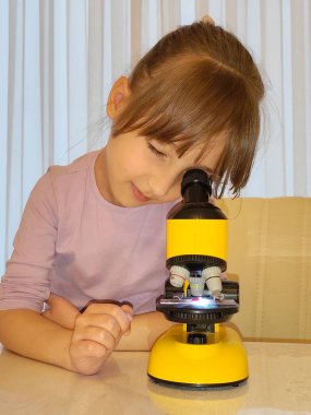 Küçük kız ve mikroskop. Yüksek kalite fotoğraf