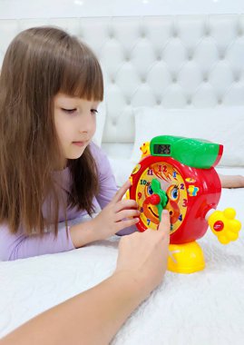 Küçük kız saati teker teker öğreniyor. Yüksek kalite fotoğraf