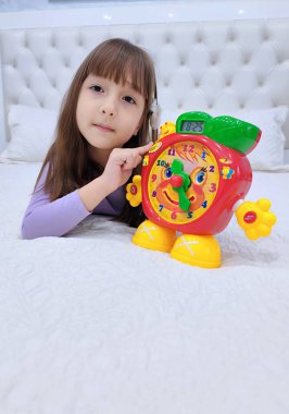 Küçük kız saati teker teker öğreniyor. Yüksek kalite fotoğraf