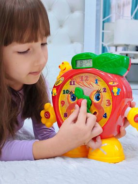 Küçük kız saati teker teker öğreniyor. Yüksek kalite fotoğraf