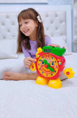 Küçük kız saati teker teker öğreniyor. Yüksek kalite fotoğraf