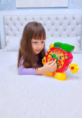 Küçük kız saati teker teker öğreniyor. Yüksek kalite fotoğraf