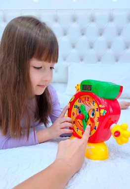 Küçük kız saati teker teker öğreniyor. Yüksek kalite fotoğraf