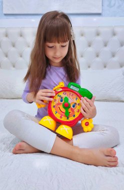 Küçük kız saati teker teker öğreniyor. Yüksek kalite fotoğraf