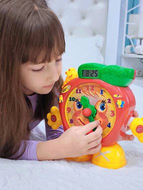 Küçük kız saati teker teker öğreniyor. Yüksek kalite fotoğraf