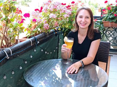 Kokkuyruklu kadın çiçek açan balkonda oturuyor. Yüksek kalite fotoğraf