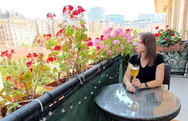 Kokkuyruklu kadın çiçek açan balkonda oturuyor. Yüksek kalite fotoğraf