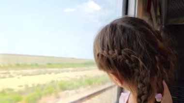Küçük kız trenin penceresinden dışarı bakıyor. Yüksek kalite 4k görüntü