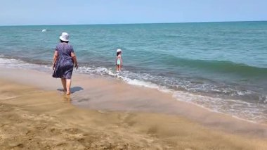 Büyükanne ve küçük kız deniz kenarında. Yüksek kalite.