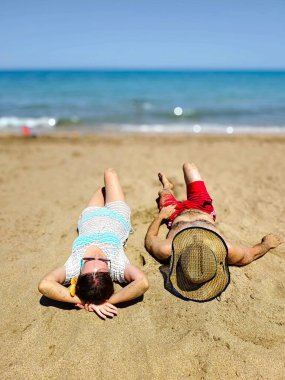 Çiftler kumsalda kumsalda uzanıyorlar. Yüksek kalite fotoğraf