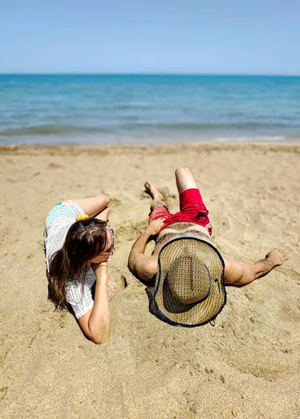 Çiftler kumsalda kumsalda uzanıyorlar. Yüksek kalite fotoğraf