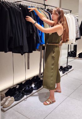 Genç bayan dükkanda kıyafet arıyor. Yüksek kalite fotoğraf