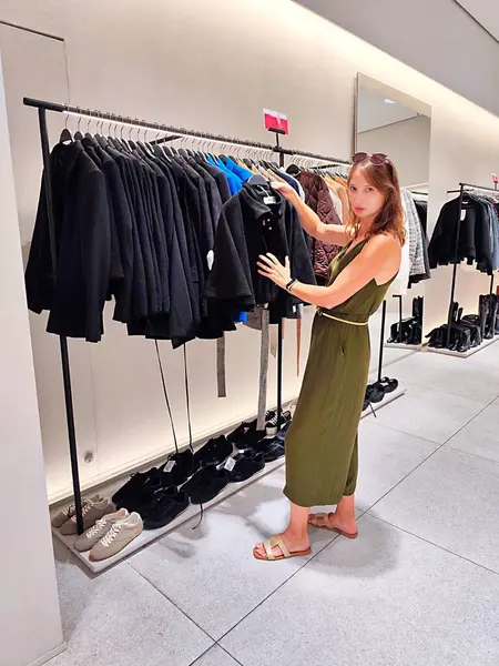 Genç bayan dükkanda kıyafet arıyor. Yüksek kalite fotoğraf