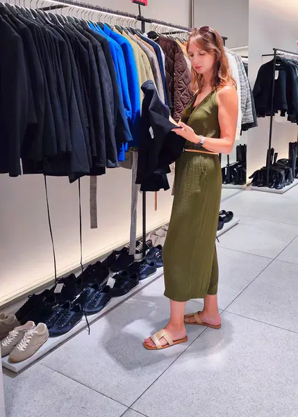 Genç bayan dükkanda kıyafet arıyor. Yüksek kalite fotoğraf
