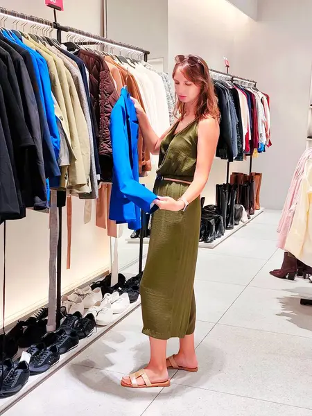 Genç bayan dükkanda kıyafet arıyor. Yüksek kalite fotoğraf