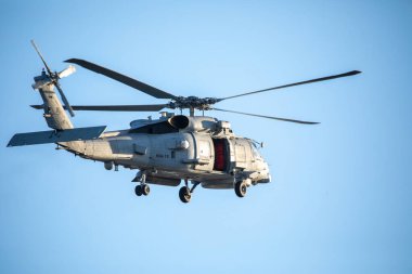 A U.S. Navy Helicopter Flying Overhead. High quality photo clipart