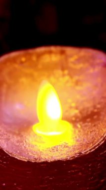 burning candle with reflection of water on a dark background