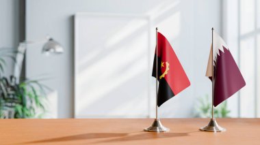 FLAGS OF  ANGOLA AND QATAR  ON TABLE clipart