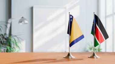 FLAGS OF BOSNIA AND SOUTH SUDAN ON TABLE