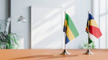 FLAGS OF GABON AND SEYCHELLES ON TABLE clipart