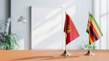 FLAGS OF MONTENEGRO AND ZIMBABWE ON TABLE clipart