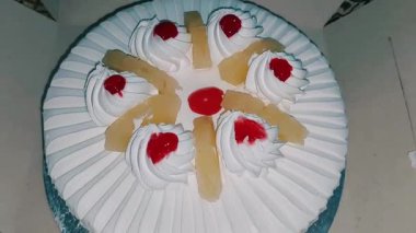Güzel beyaz kremalı mutlu doğum günü pastası ve ananas parçaları. 
